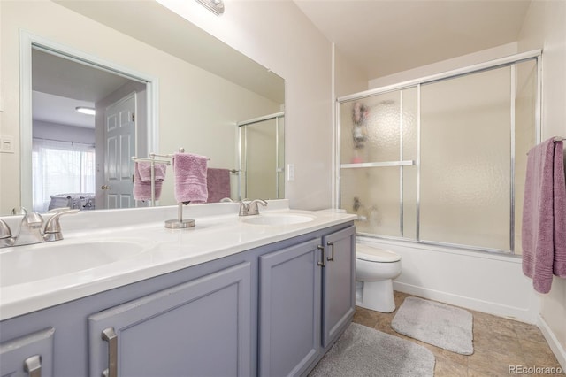 full bathroom with double vanity, toilet, and enclosed tub / shower combo