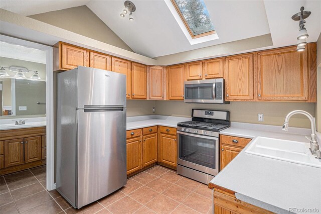 28532 Shadow Mountain Dr, Conifer, CO 80433 - kitchen featuring stainless steel appliances, a sink, a skylight, light tile patterned floors, and lofted ceiling