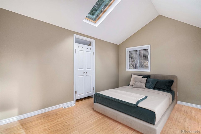 28532 Shadow Mountain Dr, Conifer, CO 80433 - bedroom featuring a skylight, light wood-style flooring, baseboards, and lofted ceiling