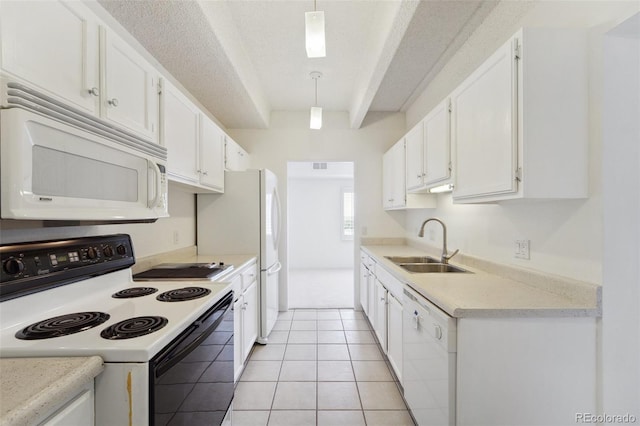 kitchen with white appliances, light countertops, white cabinets, a sink, and light tile patterned floors