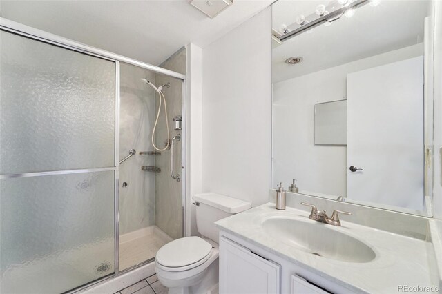 full bathroom with vanity, tile patterned flooring, toilet, and a shower stall