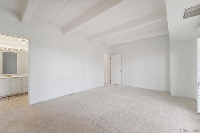 unfurnished room featuring beamed ceiling, light carpet, and visible vents