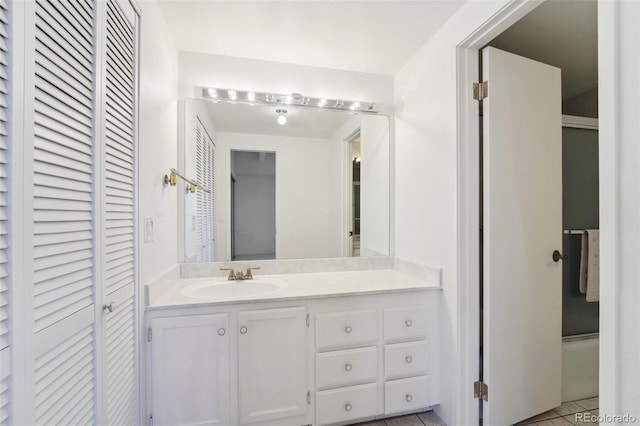 full bath with vanity, a closet, and tile patterned floors