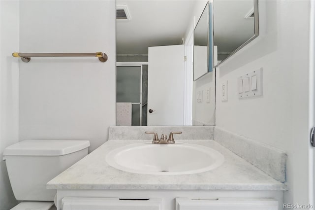 bathroom featuring an enclosed shower, vanity, toilet, and visible vents