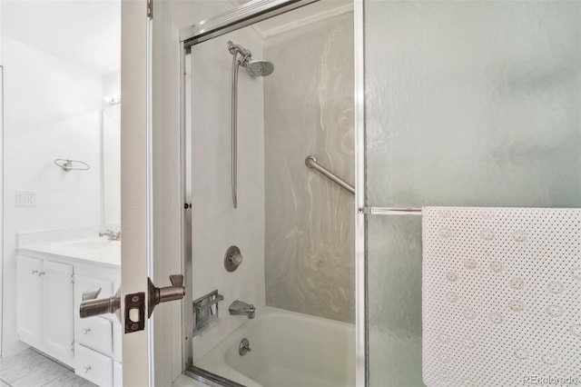 bathroom featuring combined bath / shower with glass door and vanity