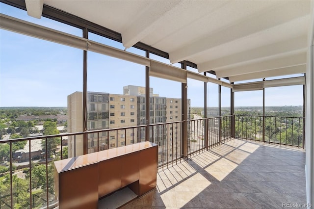 unfurnished sunroom featuring floor to ceiling windows, beamed ceiling, and a wealth of natural light
