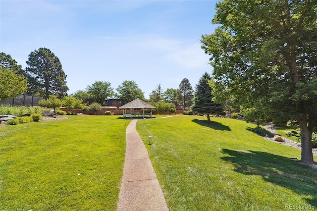 view of property's community featuring a gazebo, a lawn, and fence