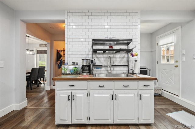 31551 Black Widow Dr, Conifer, CO 80433 - kitchen with dark wood-style flooring, white cabinetry, and tasteful backsplash