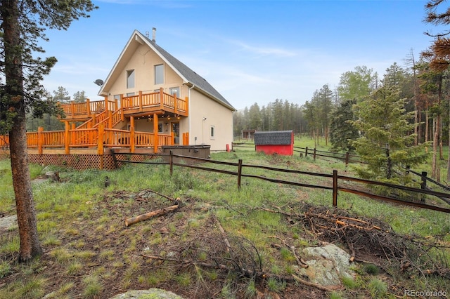 31551 Black Widow Dr, Conifer, CO 80433 - rear view of house featuring a wooden deck, stairs, and an outbuilding