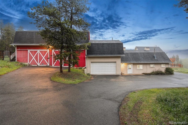 31551 Black Widow Dr, Conifer, CO 80433 - dutch colonial featuring a shingled roof, a garage, a barn, driveway, and an outbuilding