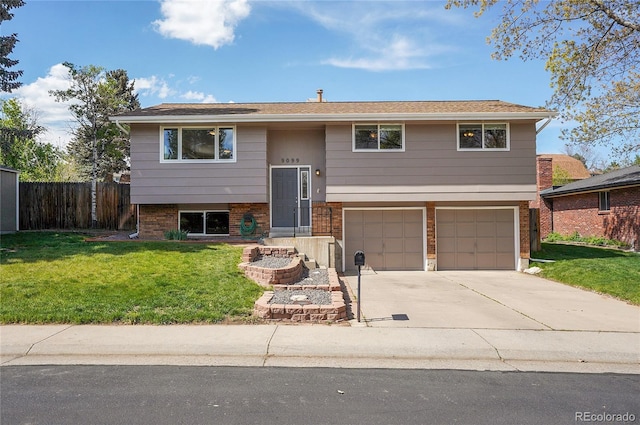 9099 W Harvard Pl, Lakewood, CO 80227 - split foyer home with a garage, concrete driveway, and brick siding