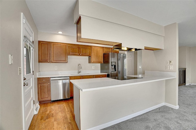 9099 W Harvard Pl, Lakewood, CO 80227 - kitchen featuring appliances with stainless steel finishes, a sink, brown cabinets, a peninsula, and light countertops