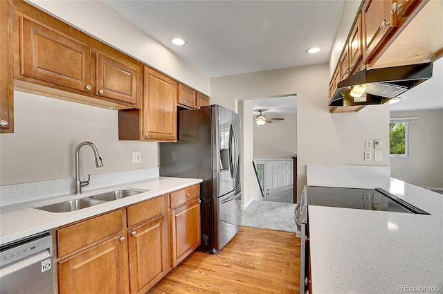 9099 W Harvard Pl, Lakewood, CO 80227 - kitchen with a sink, appliances with stainless steel finishes, under cabinet range hood, brown cabinets, and recessed lighting