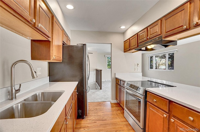 9099 W Harvard Pl, Lakewood, CO 80227 - kitchen featuring appliances with stainless steel finishes, under cabinet range hood, a sink, light wood-type flooring, and recessed lighting