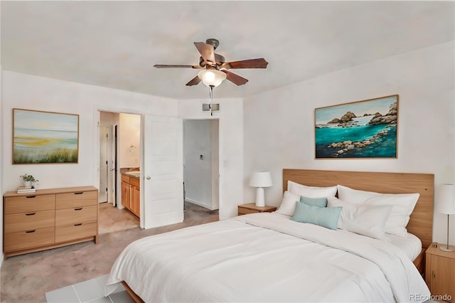 bedroom with ensuite bathroom, ceiling fan, and light carpet