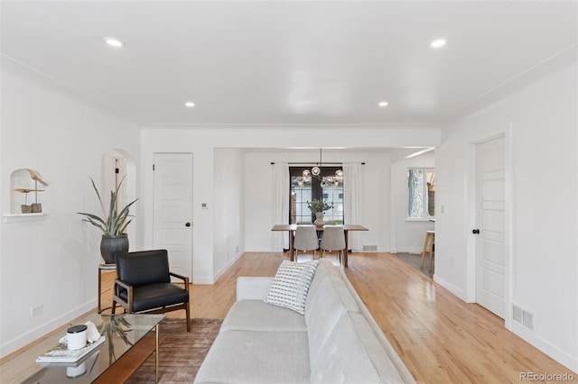 3440 N Harrison St, Denver, CO 80205 - living room featuring light wood-style flooring, recessed lighting, arched walkways, and a chandelier