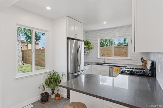 3440 N Harrison St, Denver, CO 80205 - kitchen with healthy amount of natural light, tasteful backsplash, appliances with stainless steel finishes, dark countertops, and recessed lighting