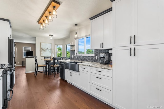 6858 Otis Ct, Arvada, CO 80003 - kitchen with dishwashing machine, range, tasteful backsplash, dark wood-style floors, and white cabinetry
