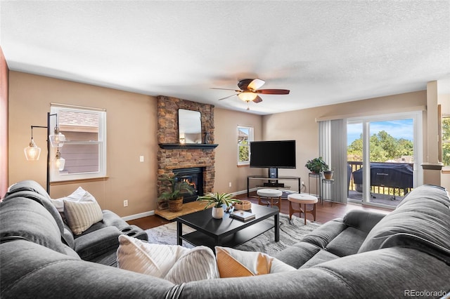 6858 Otis Ct, Arvada, CO 80003 - living area with ceiling fan, wood finished floors, healthy amount of natural light, and a stone fireplace