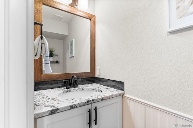 6858 Otis Ct, Arvada, CO 80003 - bathroom with vanity, wainscoting, and a textured wall