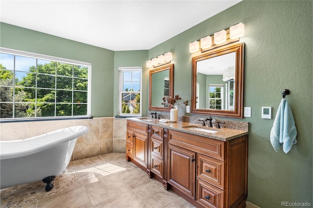 6858 Otis Ct, Arvada, CO 80003 - bathroom with double vanity, plenty of natural light, a freestanding bath, a textured wall, and tile patterned floors