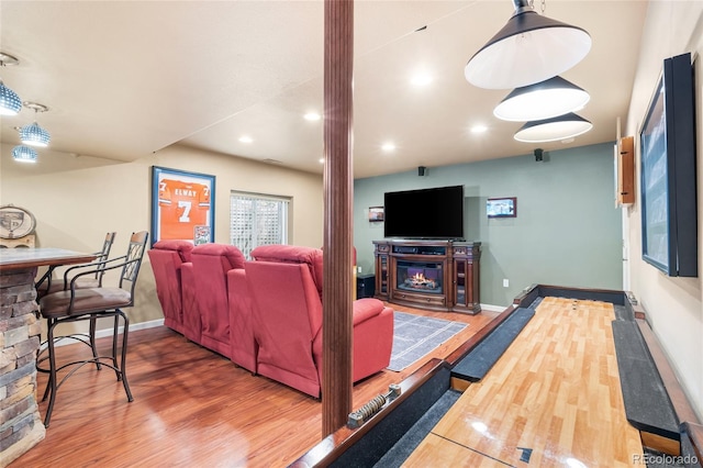 6858 Otis Ct, Arvada, CO 80003 - living room featuring decorative columns, wood finished floors, a glass covered fireplace, and recessed lighting
