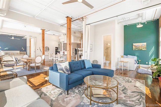 living room featuring wood finished floors, baseboards, and ceiling fan