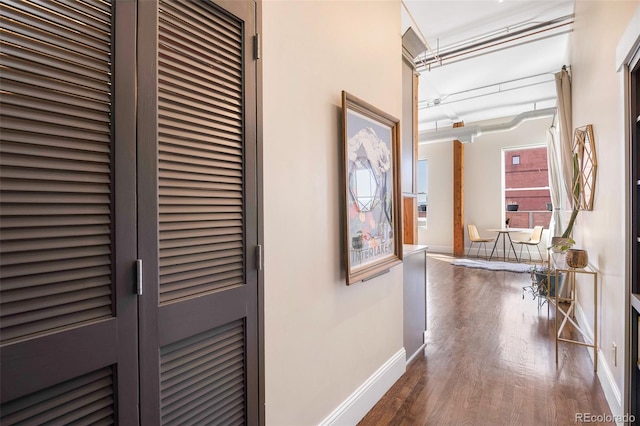 hallway with baseboards and wood finished floors