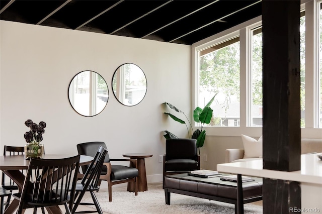dining room featuring light colored carpet and baseboards