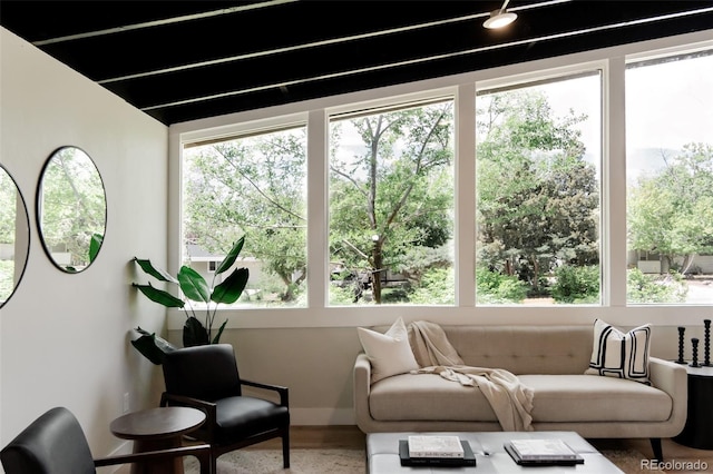 living area with plenty of natural light, wood finished floors, and baseboards