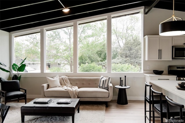 living area with baseboards and light wood-style flooring
