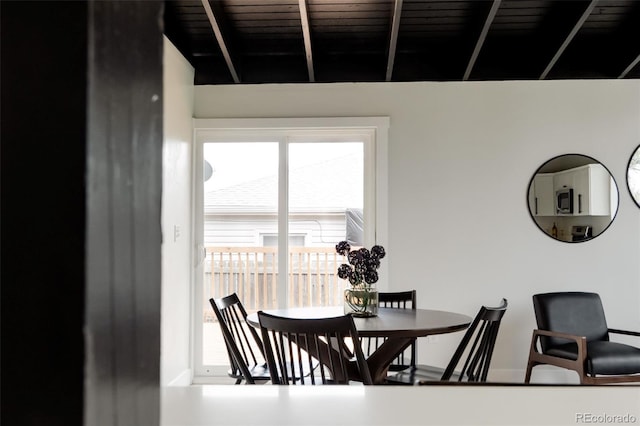 dining area with baseboards and beamed ceiling
