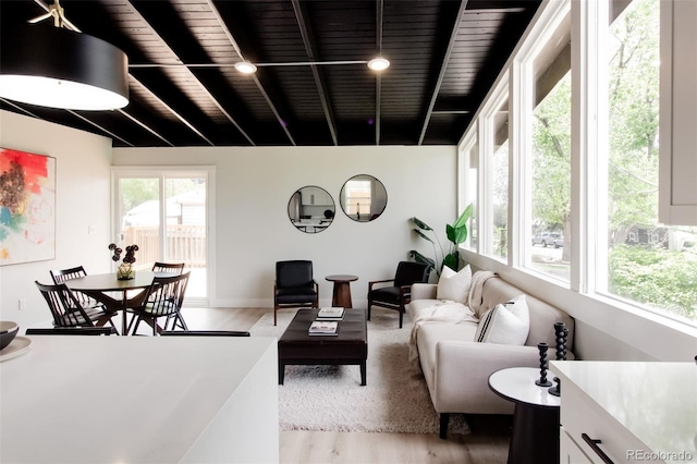 living area featuring light wood-type flooring and beam ceiling
