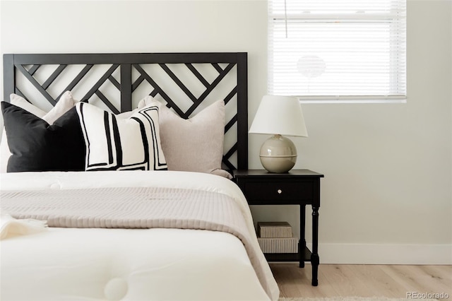 bedroom with wood finished floors and baseboards