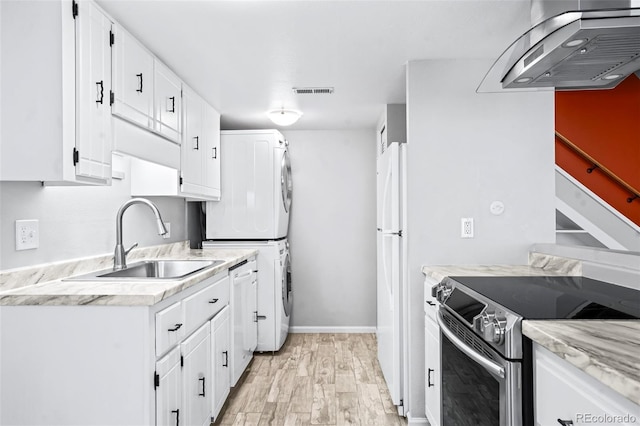 kitchen with ventilation hood, sink, white cabinets, stacked washer and clothes dryer, and white appliances