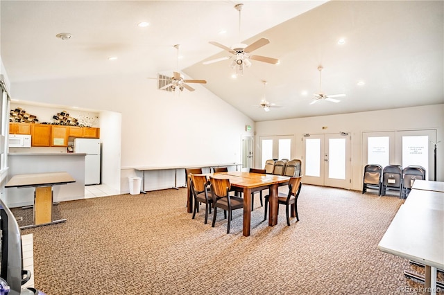 dining area featuring light carpet, french doors, and high vaulted ceiling