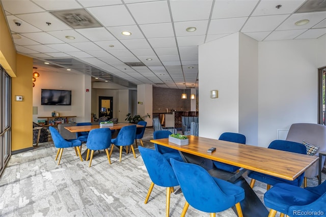 dining space featuring a paneled ceiling and light colored carpet