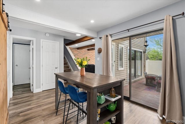 dining space with stairs, a barn door, recessed lighting, and light wood-style floors