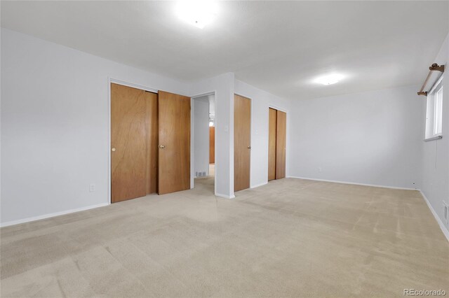 3022 Blackhawk St, Aurora, CO 80011 - unfurnished bedroom with two closets, baseboards, and light colored carpet
