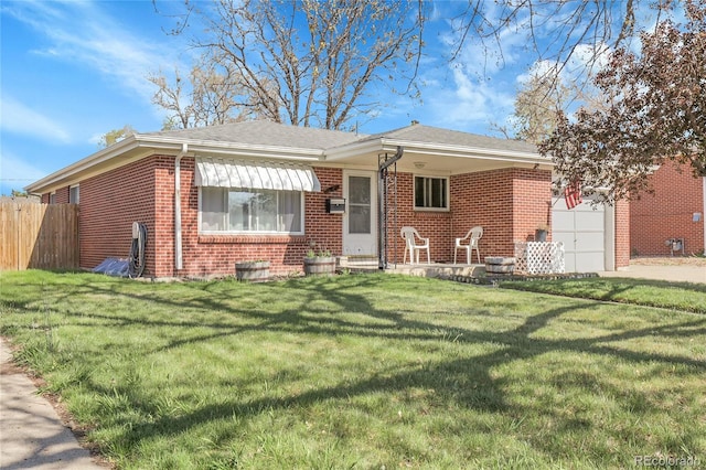 3022 Blackhawk St, Aurora, CO 80011 - view of front of house featuring a front lawn, fence, brick siding, a shingled roof, and an attached garage