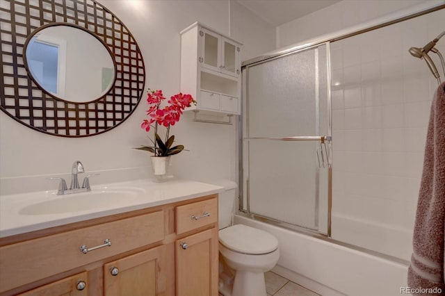 full bathroom featuring tile patterned flooring, vanity, toilet, and combined bath / shower with glass door