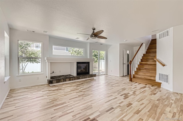 18807 E 51st Pl, Denver, CO 80249 - unfurnished living room featuring light wood-type flooring, a ceiling fan, baseboards, stairs, and a fireplace