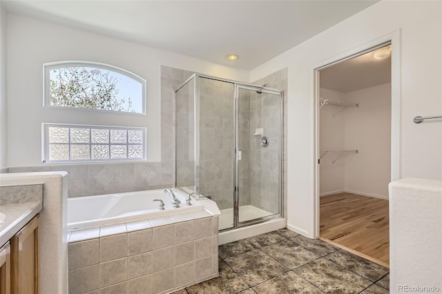 18807 E 51st Pl, Denver, CO 80249 - full bathroom featuring a shower stall, a bath, a walk in closet, vanity, and recessed lighting