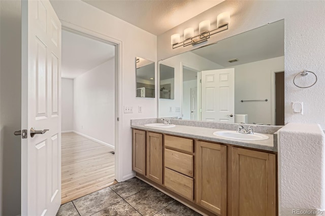 18807 E 51st Pl, Denver, CO 80249 - full bath with double vanity, tile patterned floors, and baseboards