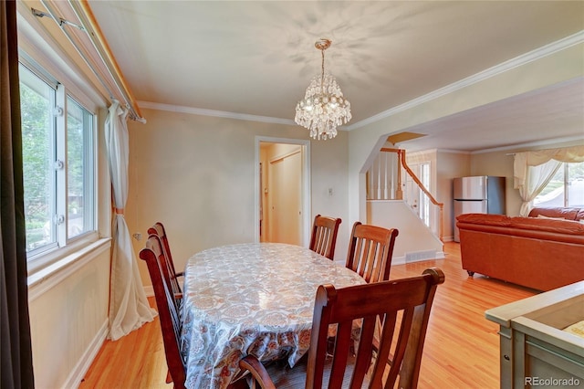 6971 S Valentia St, Centennial, CO 80112 - dining area featuring a chandelier, light wood-style floors, baseboards, stairway, and crown molding