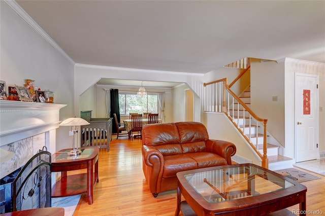 6971 S Valentia St, Centennial, CO 80112 - living room with a premium fireplace, light wood-type flooring, ornamental molding, stairs, and a chandelier