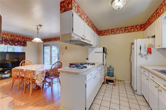 6971 S Valentia St, Centennial, CO 80112 - kitchen featuring white appliances, a peninsula, light countertops, and plenty of natural light