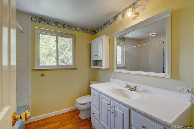6971 S Valentia St, Centennial, CO 80112 - full bathroom with vanity, toilet, wood finished floors, a tile shower, and baseboards