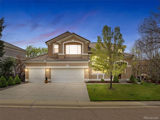 view of front of home with driveway, a tile roof, a lawn, an attached garage, and stucco siding