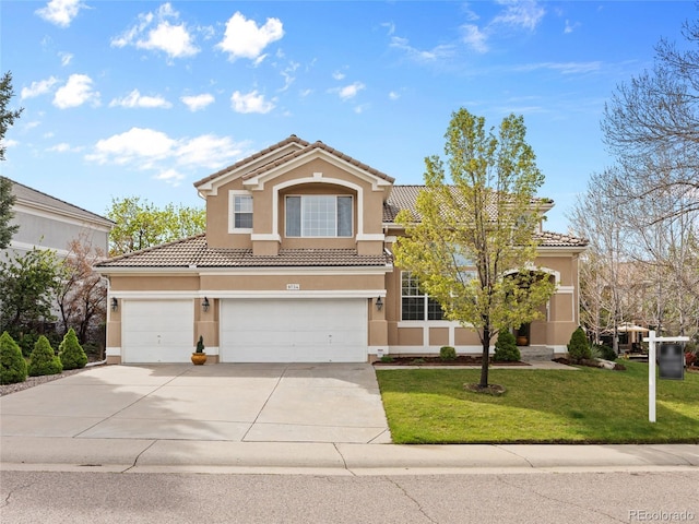 traditional home with concrete driveway, a tiled roof, a front yard, and stucco siding